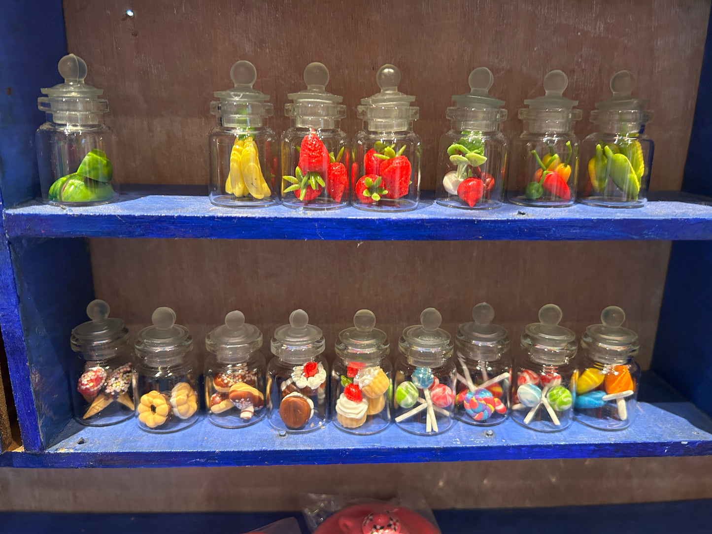 Fra musenes spiskammers ; glasskrukker fylt med frukt og søtsaker. Miniatyrer.