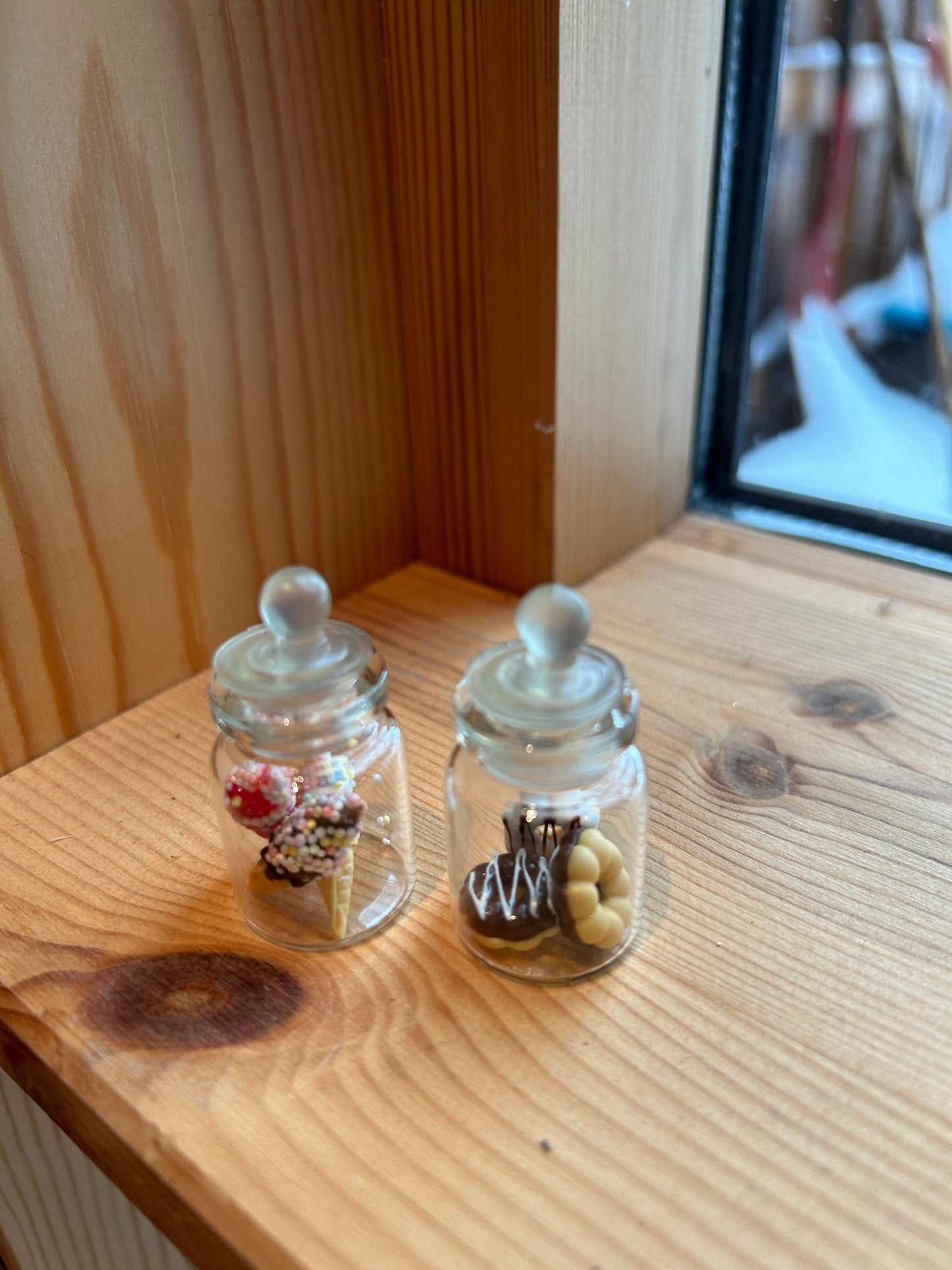 Fra musenes spiskammers ; glasskrukker fylt med frukt og søtsaker. Miniatyrer.