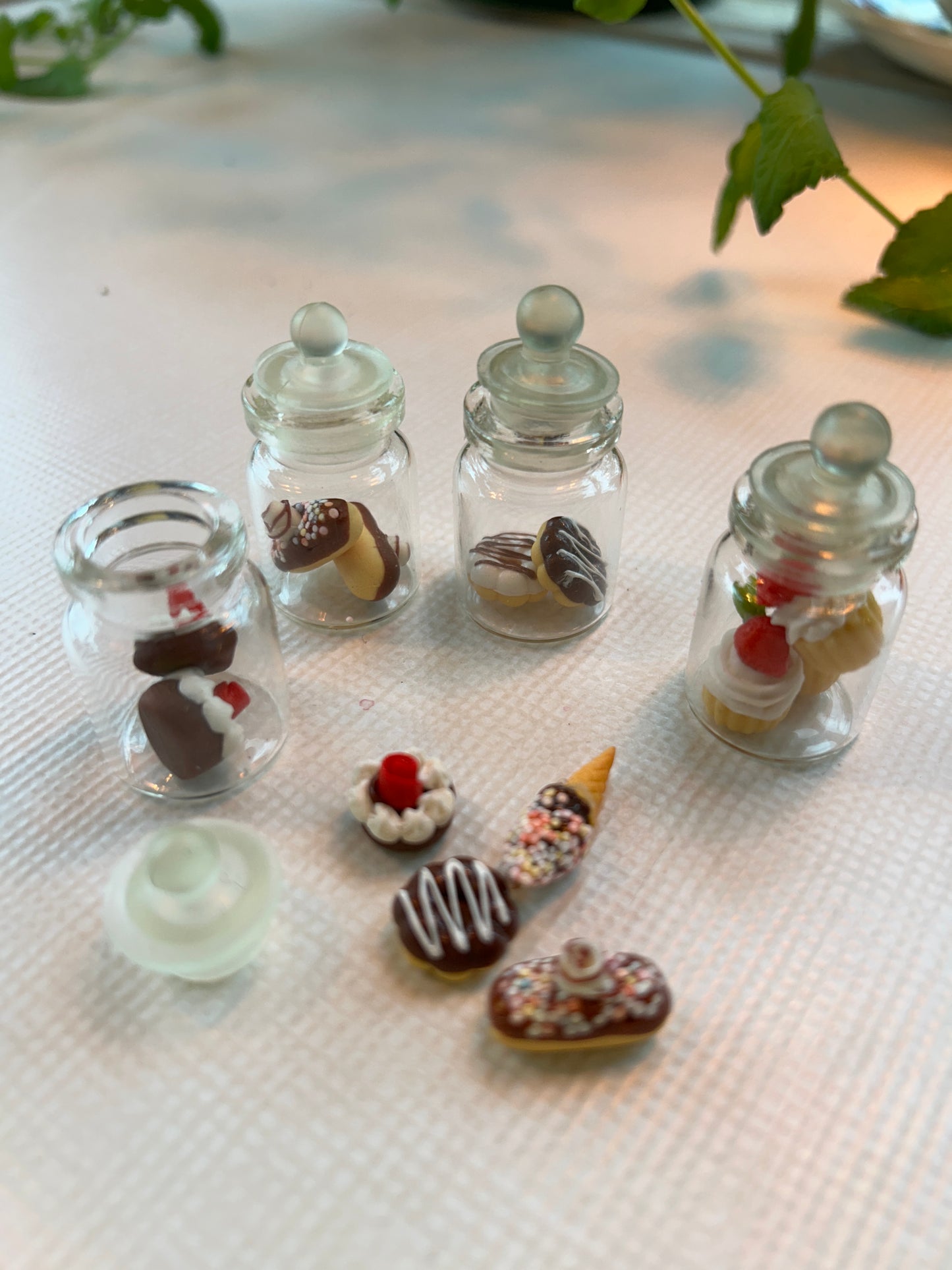 Fra musenes spiskammers ; glasskrukker fylt med frukt og søtsaker. Miniatyrer.