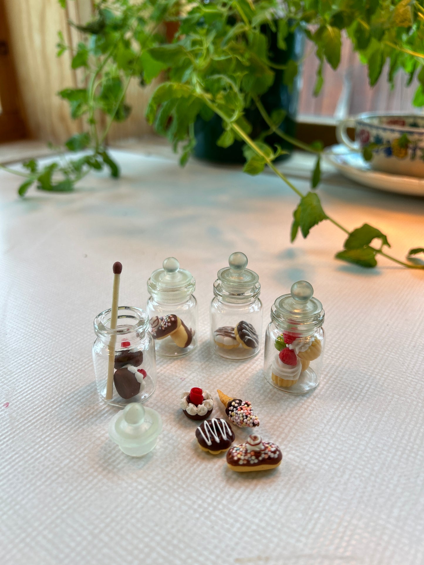 Fra musenes spiskammers ; glasskrukker fylt med frukt og søtsaker. Miniatyrer.